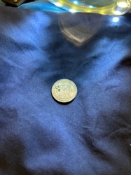 Could potentially be a Shilling, Sixpence, or similar denomination of British coinage.